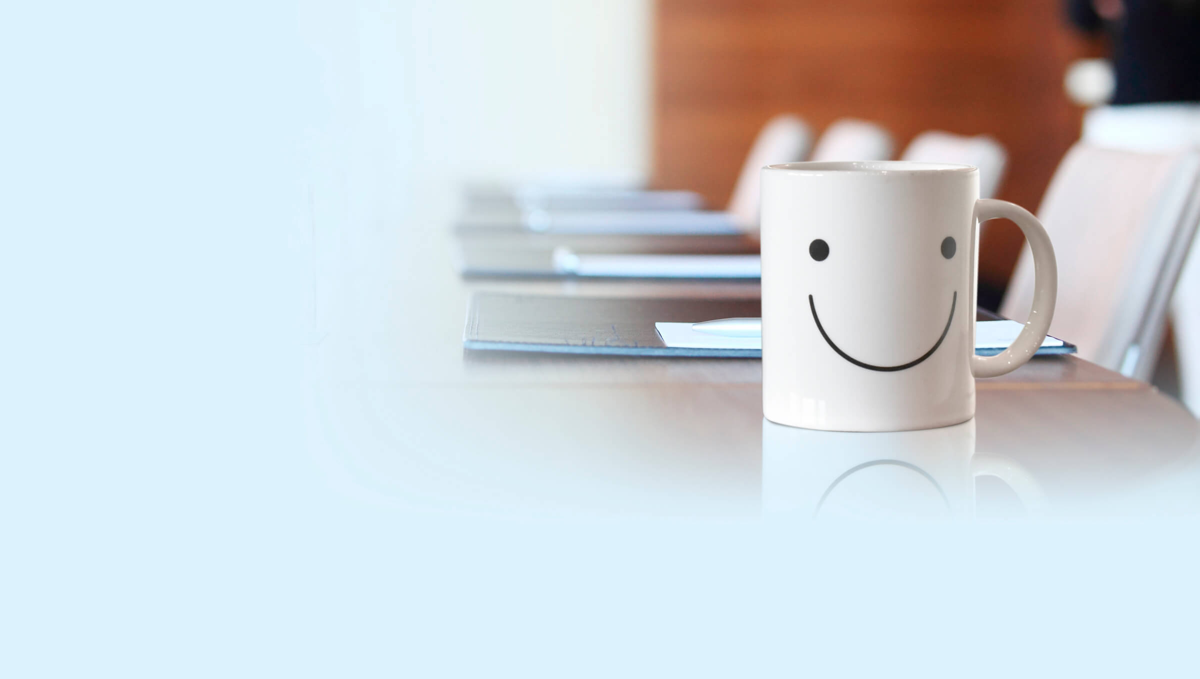 Mug on office desk with smiley face printed on the mug